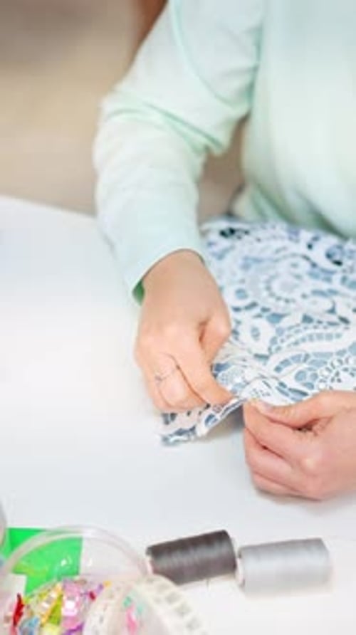 Seamstress Hand Sewing Lace Fabric in a Sewing Workshop