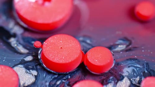 Des gouttes d'encre rouge éclatantes se dilatant dans l'eau, créant des motifs abstraits