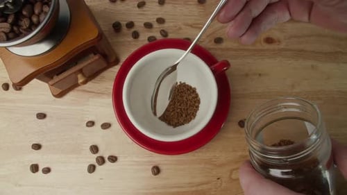 Close Up Teaspoon of Coffee Into a Red Mug Freezedried Coffee Dipped Into a Red Cup Coffee Granules