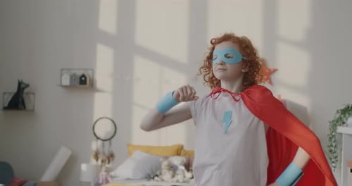Slow Motion of Little Girl Wearing Mask and Cape Standing in Superhero Pose Smiling Playing Game at