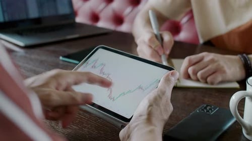 Analistas financeiros verificando o gráfico em um tablet