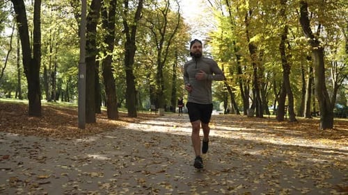 A Man Runs in an Autumn Park
