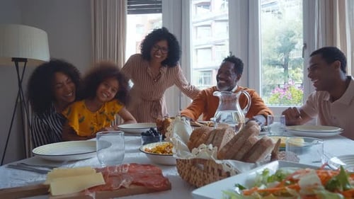 Smiling Family Gathers Around Meal Table Indoors