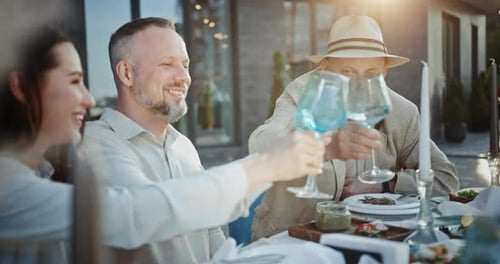 Family Clinks Glasses and Smiles Celebrating Holiday in Cafe