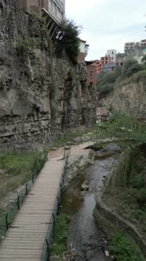 Rustic Urban Canyon with Footbridge in Tbilisi