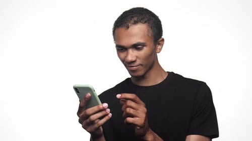 Young Adult Using Mobile Phone Against White Background