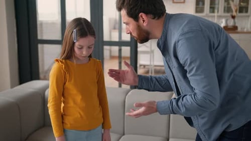 Pai caucasiano irritado, pai, fala, grita com uma garotinha ofendida, filha, filho em casa, homem irritado