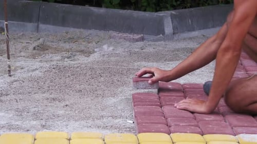 Man Laying Red and Yellow Bricks