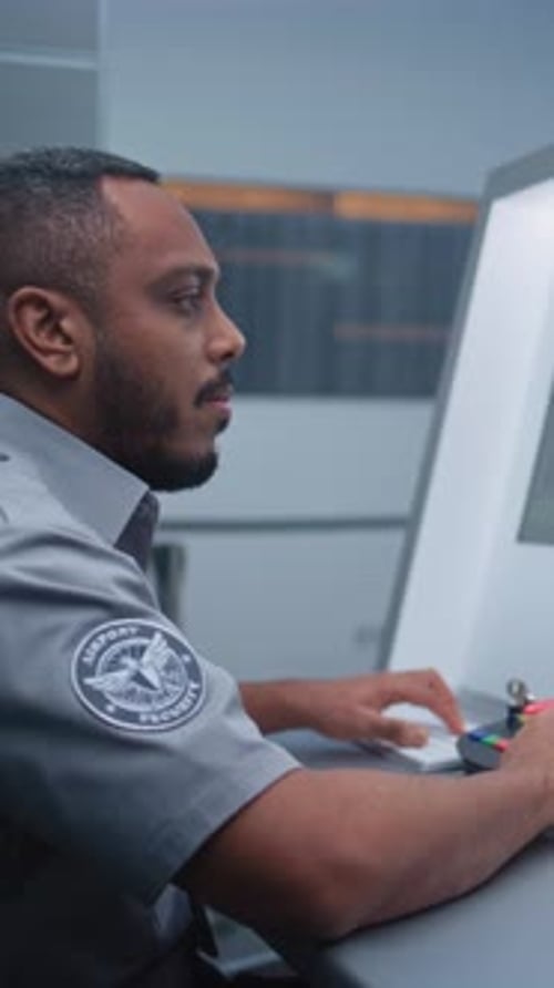 Airport Security Checkpoint Security Officer Monitors Baggage Xray Scanning on Computer Screens