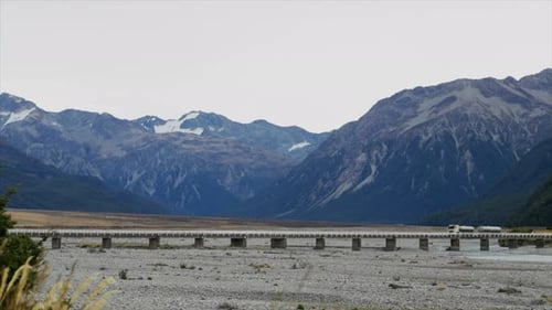 Large truck driving across a bridge over a river in Arthurs Pass New Zealand