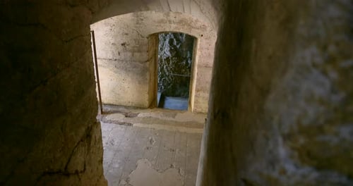 Empty stone corridor leading to mysterious dark room