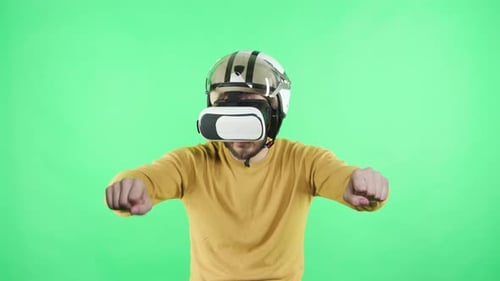 Man With VR Headset and Helmet Pretends to Drive