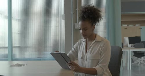 Portrait of african american female business executive in an office using a digital tablet