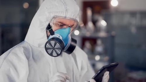 Scientist in Hazmat Suit Uses Tablet Device