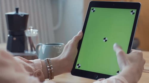 Woman Using Tablet with Green Screen in Office