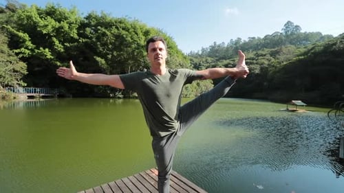 Yogi sport man doing Yoga pose outdoors by the lake