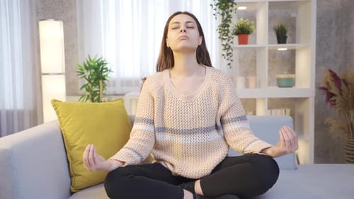 Woman Meditating on Couch in Peaceful Home