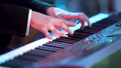 Man's hands play electronic keyboard in close up