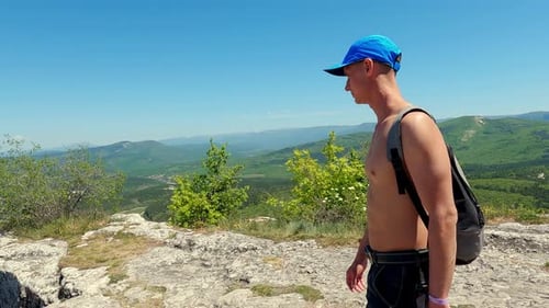 Tourist Man Hiking in Rocky Mountains Alone in Wild Nature at Sunny Day