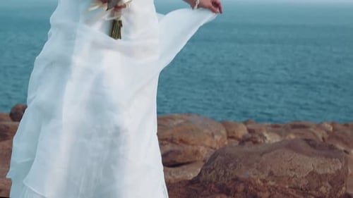Woman in Wedding Dress at Rocky Ocean Coastline