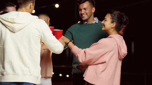 Friends Toasting Drinks at a Nighttime Celebration