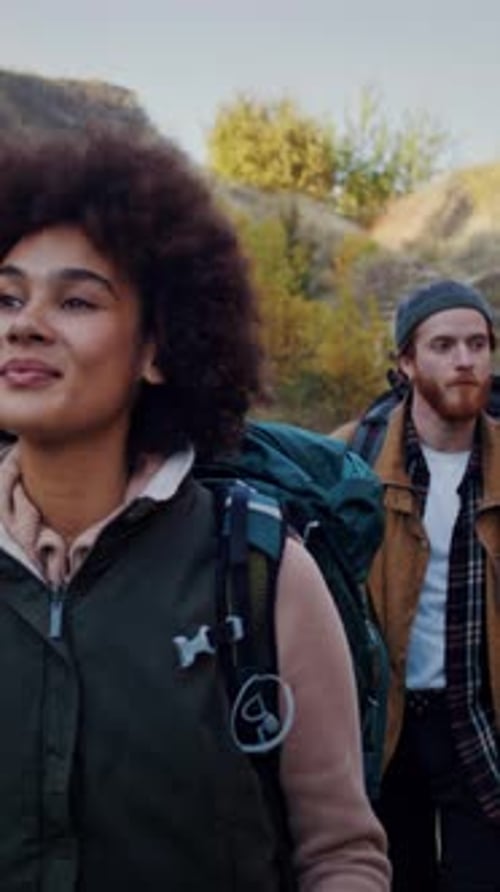 Two Young Adults Hiking Together in Nature