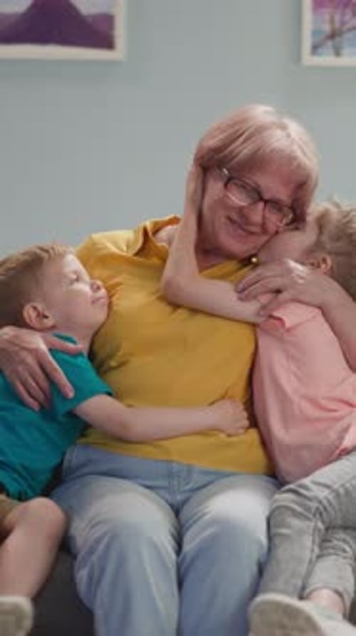 Grandmother Receives Affectionate Hugs From Grandchildren Indoors