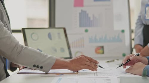 Nahaufnahme von Geschäftspartnern, die an Papierkram arbeiten und Brainstorming machen.