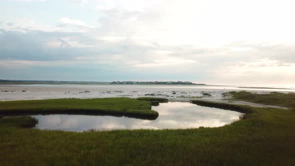 Drone flyover of pool of mason inlet marsh and beach headed towards ...