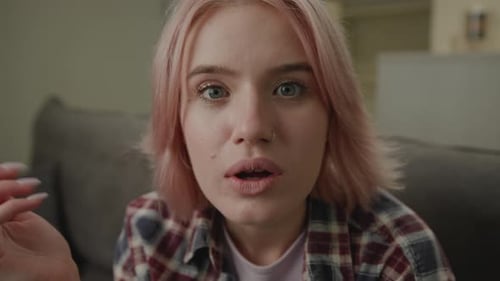 Shocked Woman with Pink Hair on Couch