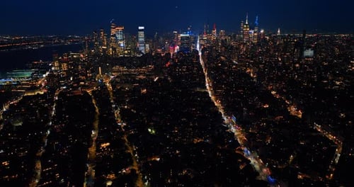 Light lines of highways in the night cityscape of New York. Luminous city from aerial perspective.