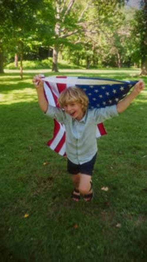 Child Runs With American Flag in Park