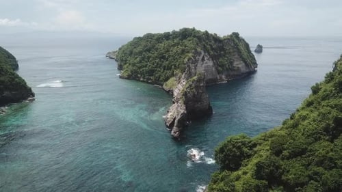 Aerial to rugged rocky Batupadasan Island on Nusa Penida, Bali