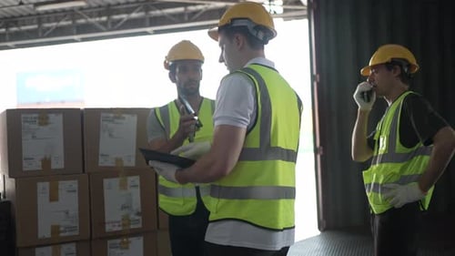 Blue collar workers are working at warehouse.