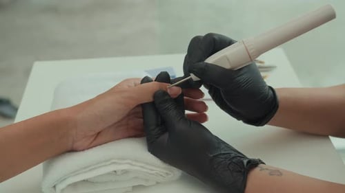 Manicurist Working on Client's Nails in Nail Salon