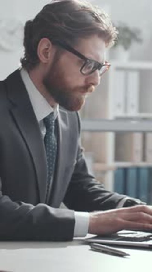 Businessman Typing on Laptop during Workday in Office