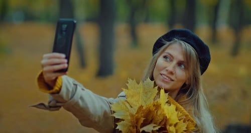Beautiful Blonde Woman Taking Selfie in Park in Autumn Holding Fallen Leaves Bunch Prores