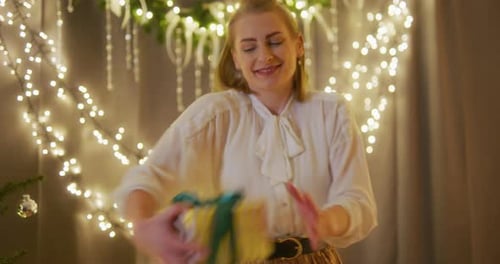 Woman Smiling and Offering a Christmas Gift