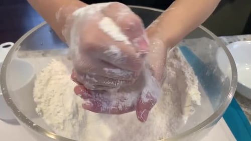 Close of up small hands playing with flour. Baking has become a popular shelter in place activity du