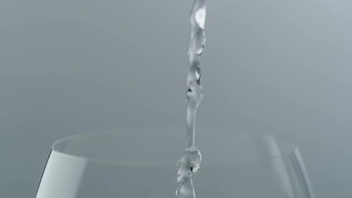 Pouring Water into Glass with Ice Cubes