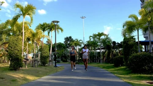 Two Asian Women Exercise Running in a Public Park in Pattaya Thailand
