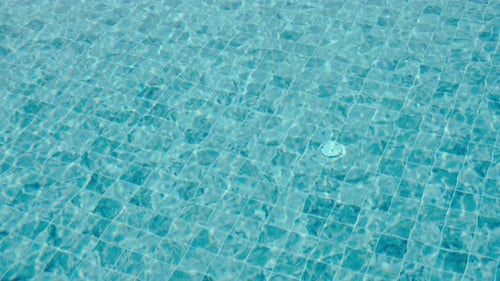 Background of ripping blue water surface in the swimming pool