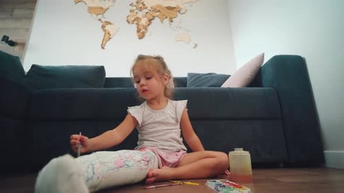 Child Painting on Leg Cast on the Floor