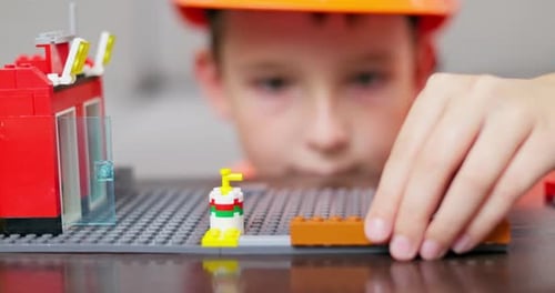 Kinderhände spielen mit bunten Plastikspielzeugsteinen und Konstruktor-Spielblöcken