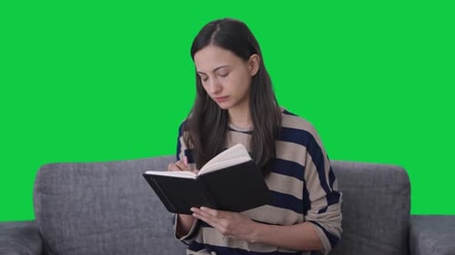Indian girl writing a book Green screen