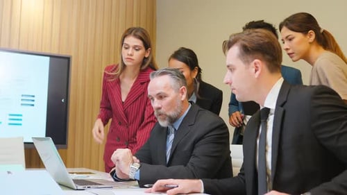 Diverse Team Discussing Data in Corporate Meeting