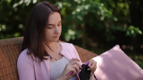 Woman Crocheting Outdoors on Patio