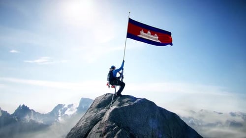 Alpiniste tenant le drapeau du Cambodge au sommet de la montagne