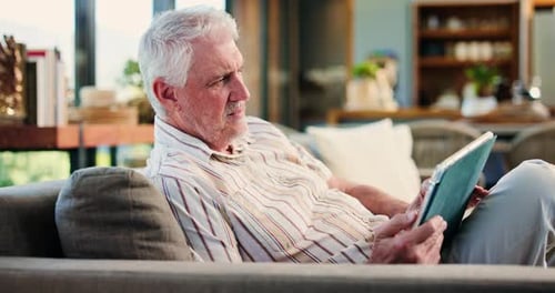 Senior Man Relaxing at Home with Tablet