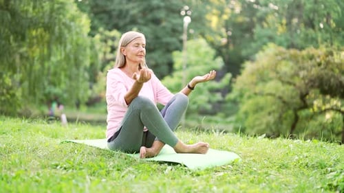 Woman Meditating Peacefully in an Urban Park